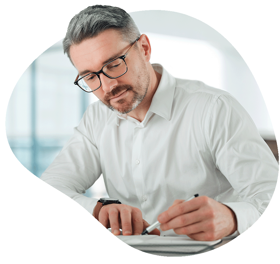 Man looking down at papers and holding pen