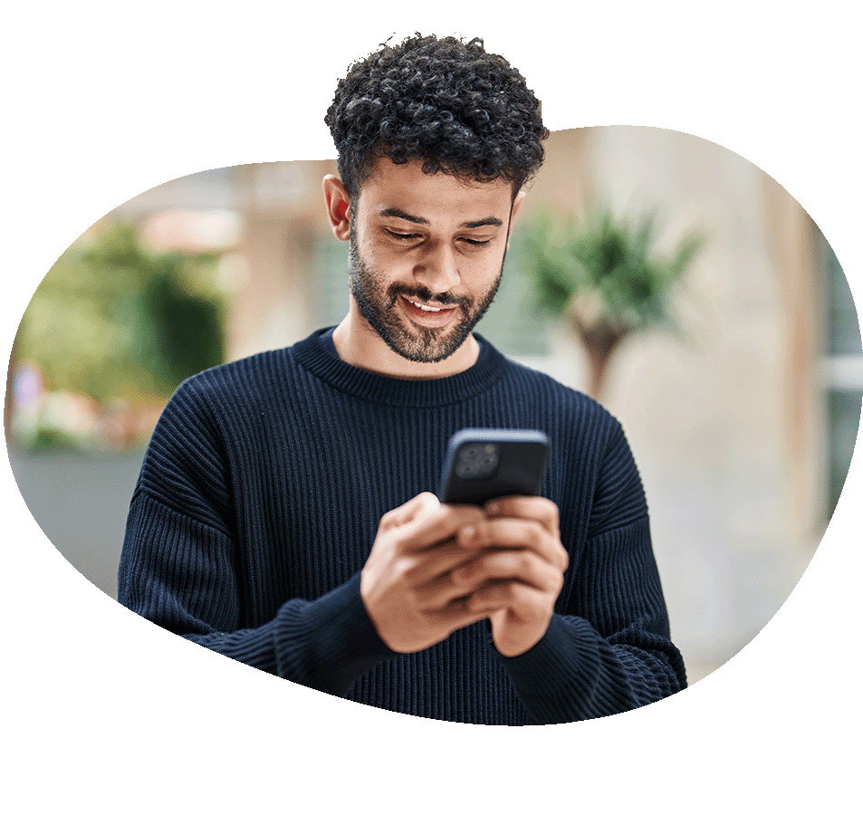 Man looking down at phone smiling