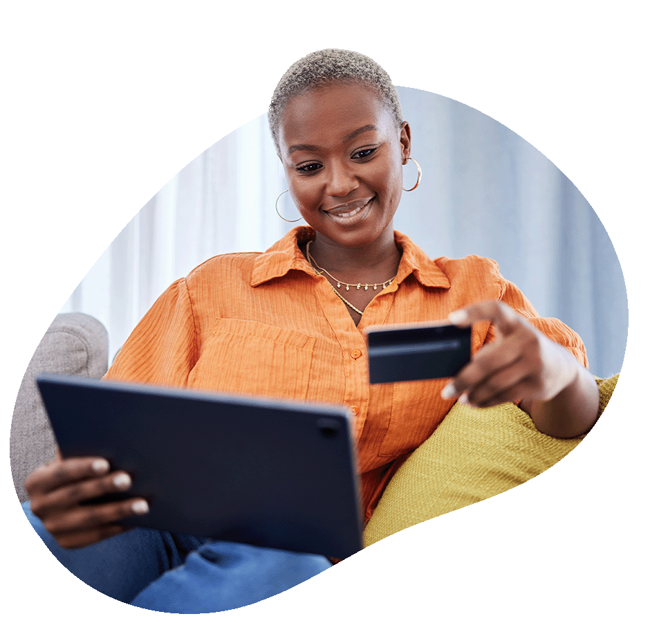 Woman looking at credit card while holding tablet
