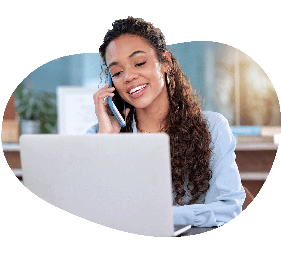 Woman on the phone and looking at laptop